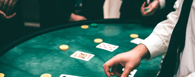 Bàn Blackjack nỉ xanh với lá Át và lá K tạo thành 21 điểm bên chồng chip cược và dòng chữ trả thưởng 3 ăn 2